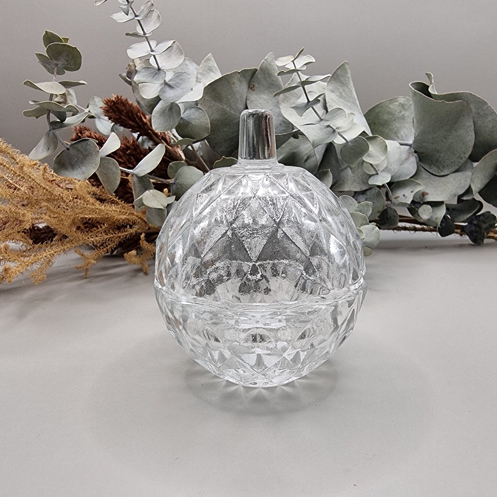 Small round vintage clear glass trinket box with diamond-faceted pattern and lid.