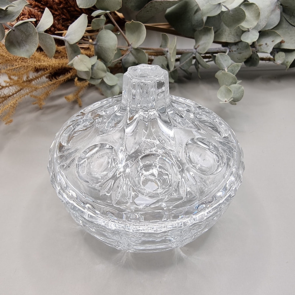 Vintage cut glass trinket box with tall lid and decorative pattern.