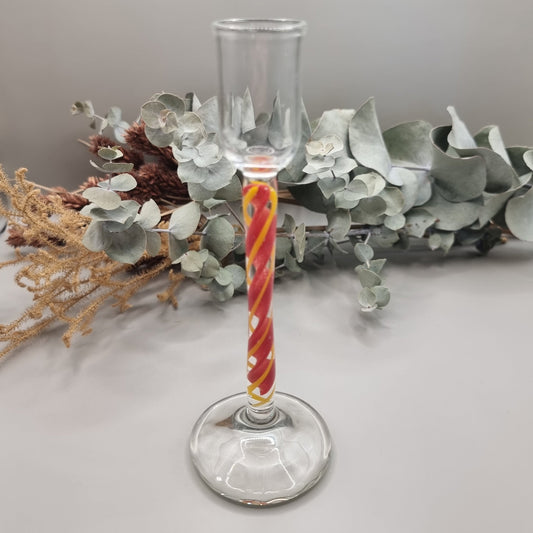 Murano-style glass candle holder with red swirl stem and clear top.