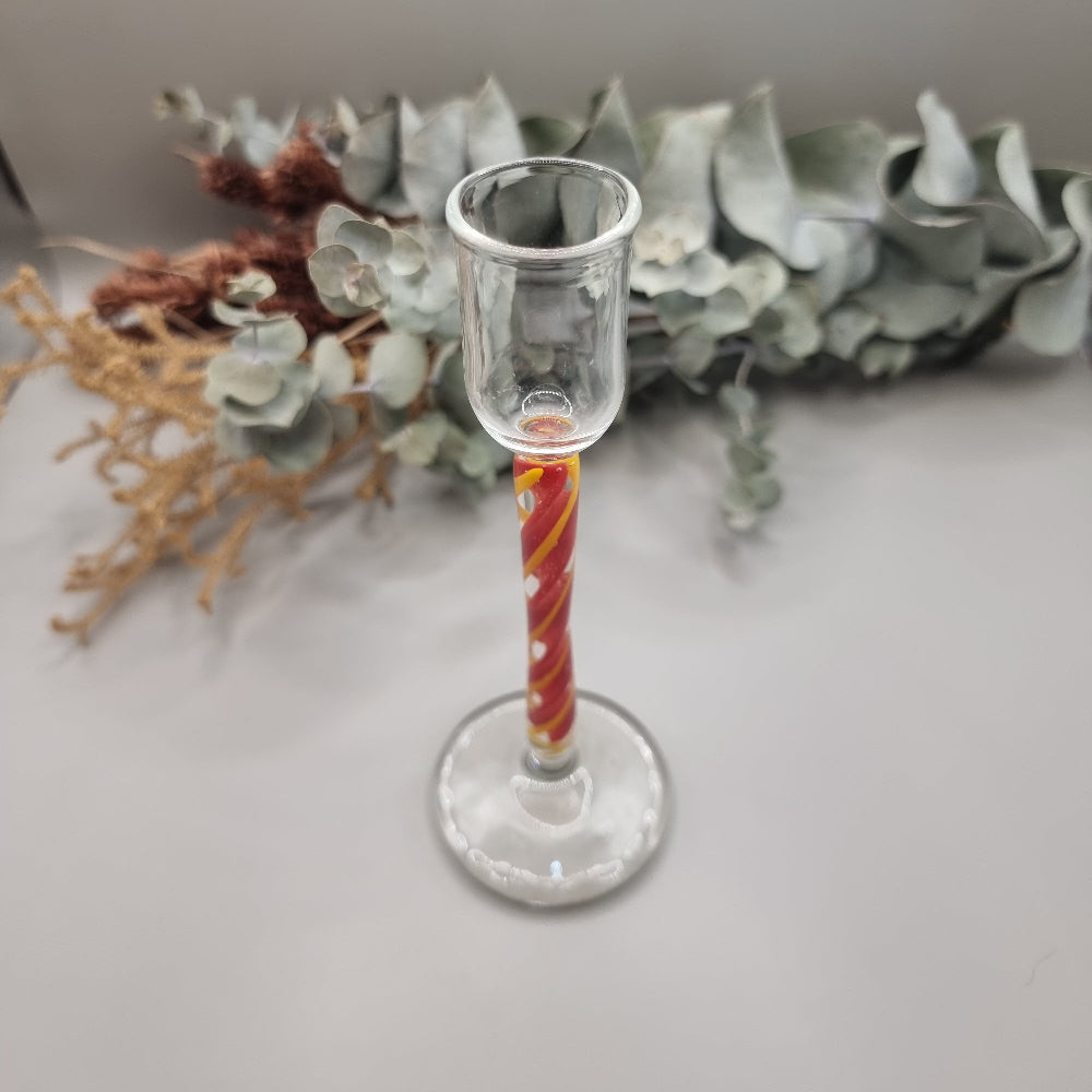 Murano-style glass candle holder with red swirl stem and clear top.