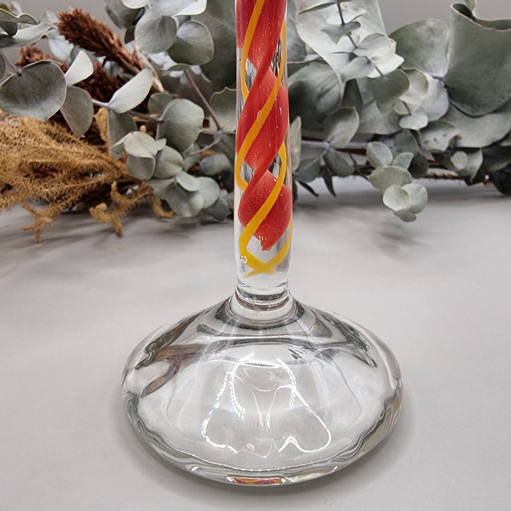 Murano-style glass candle holder with red swirl stem and clear top.