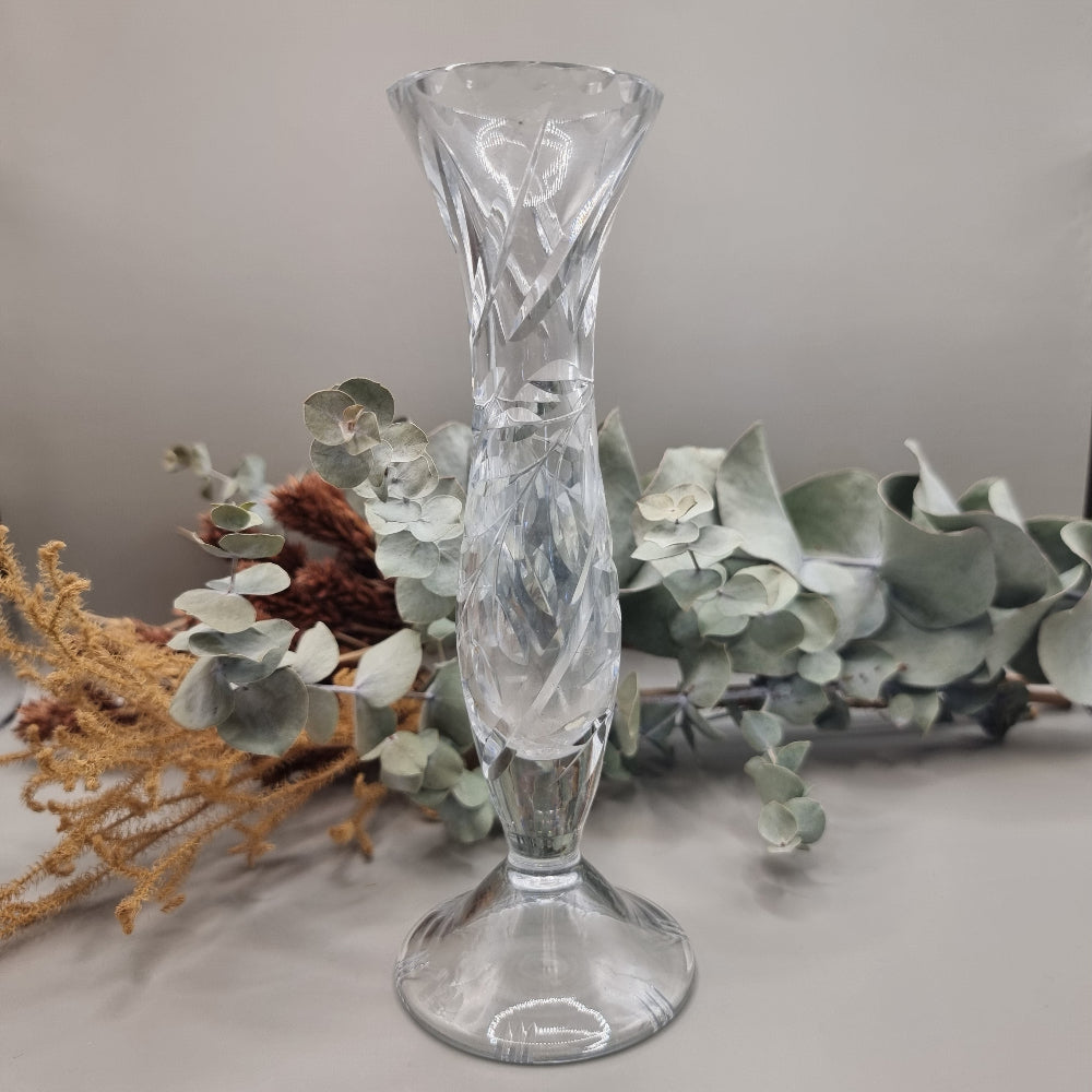 Crystal bud vase with swirl cut design and flared rim on a footed base.