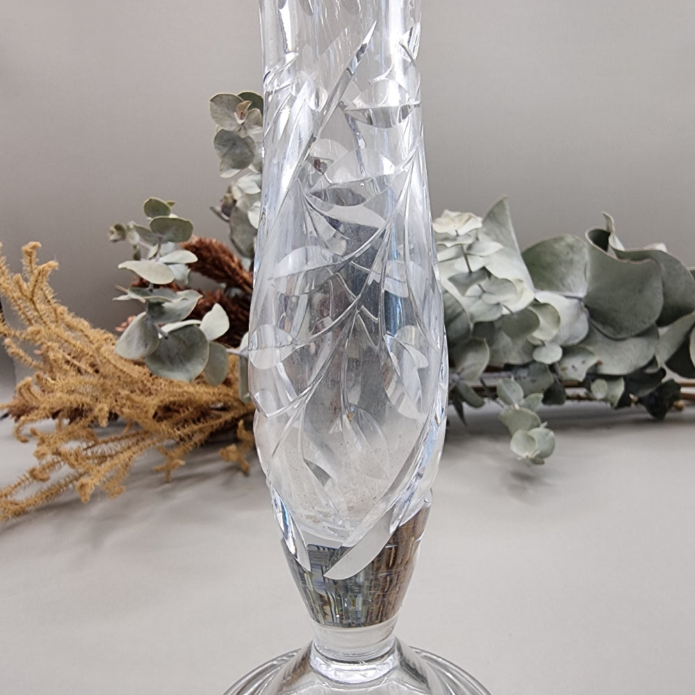 Crystal bud vase with swirl cut design and flared rim on a footed base.