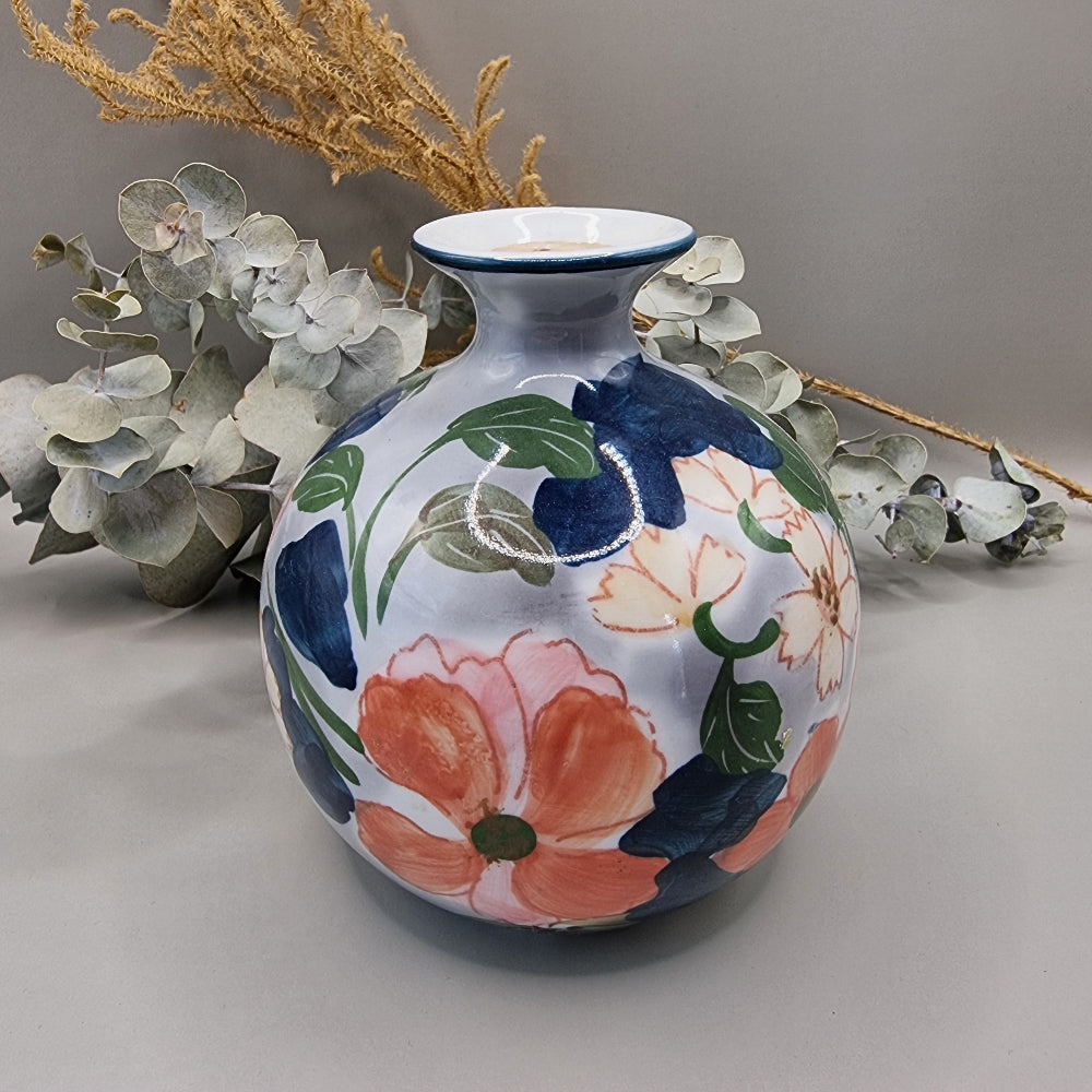 Vintage hand-painted ceramic round globe vase with large bold pink and coral floral design on white glaze, narrow navy rimmed neck