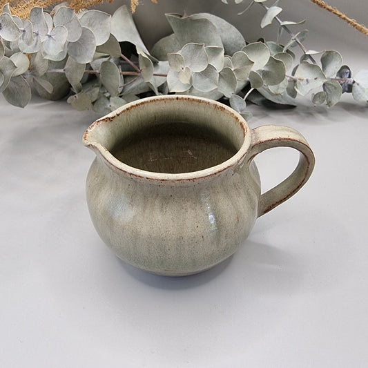 Handmade green studio pottery jug with handle and spout