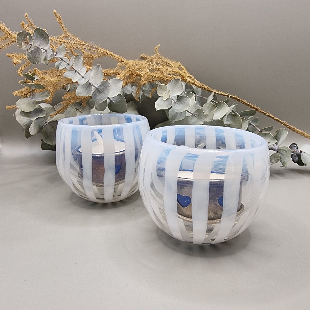 Pair of pale blue and white striped glass tealight holders with rounded shape and white vertical bands.