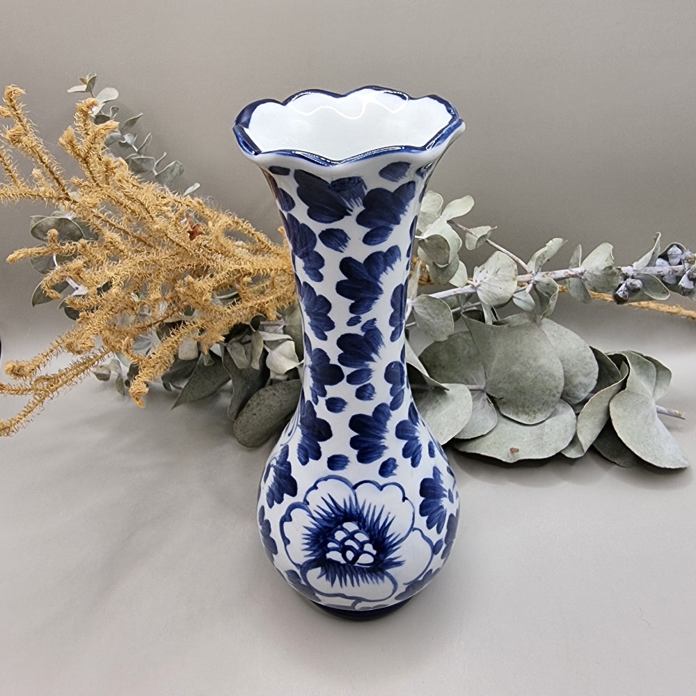 Blue and white bud vase with scalloped rim and floral pattern in dark blue.