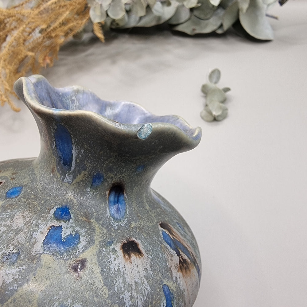 Ruffled rim ceramic vase with blue and earthy glaze, small chip on rim.