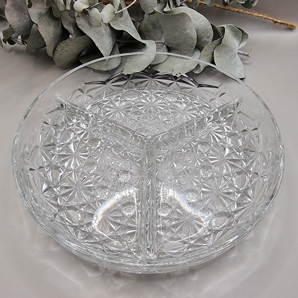 Round clear glass serving dish with starburst pattern and three divided sections.
