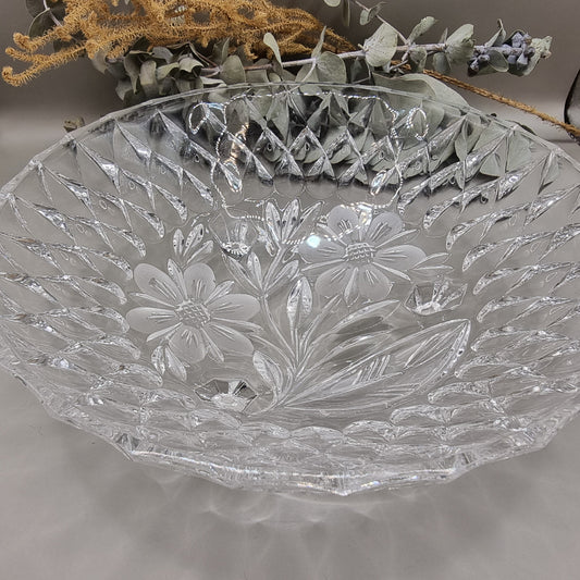 Pressed glass bowl with floral centre, diamond pattern, and three-footed base.