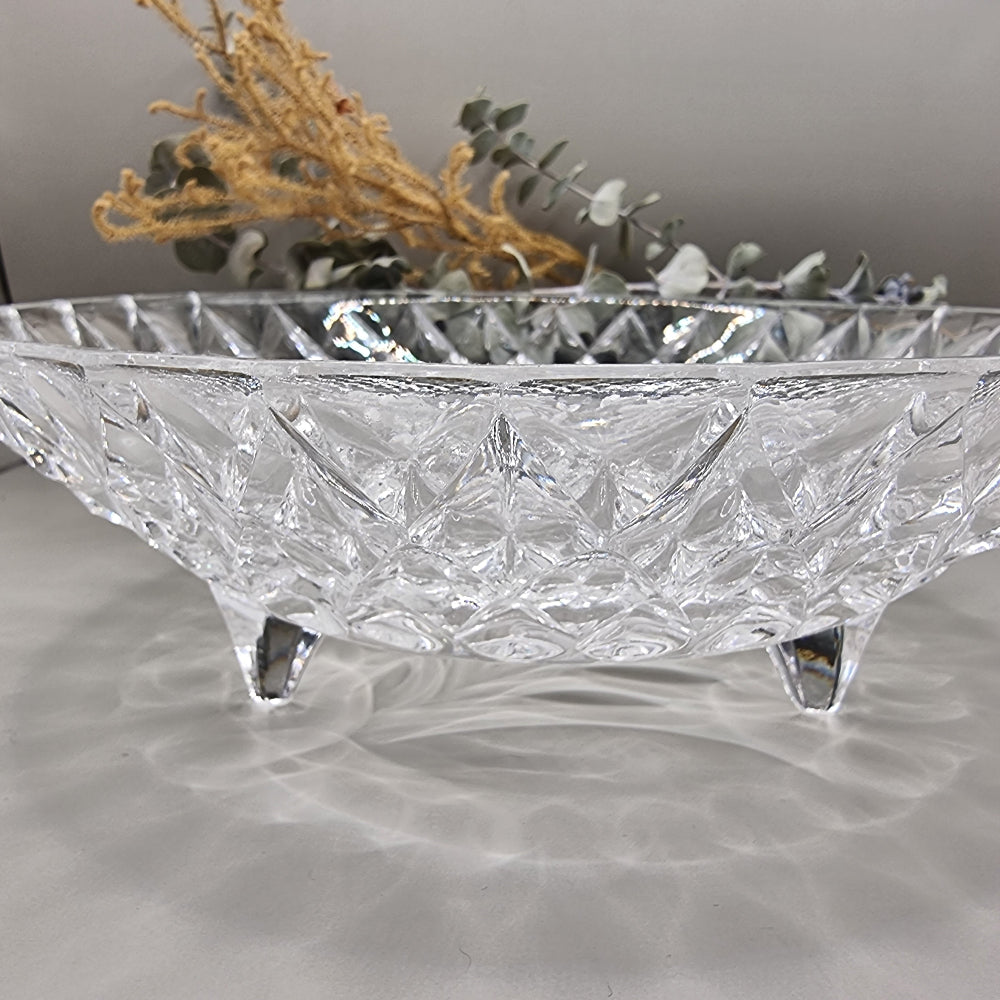 Pressed glass bowl with floral centre, diamond pattern, and three-footed base.