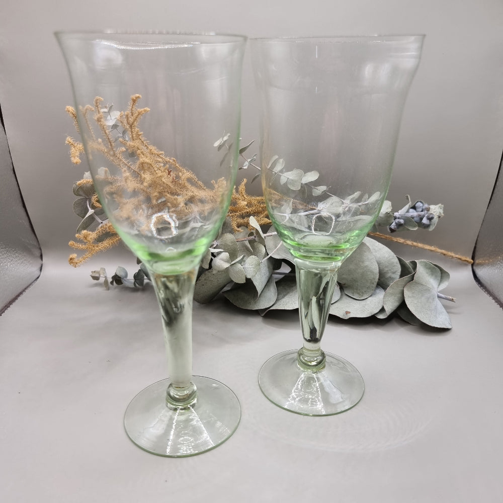 Pair of vintage green-tinted wine glasses with tall stems