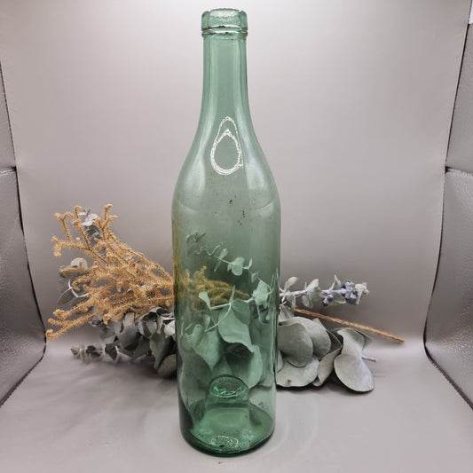 Vintage green glass bottle with soft green tint and rustic character