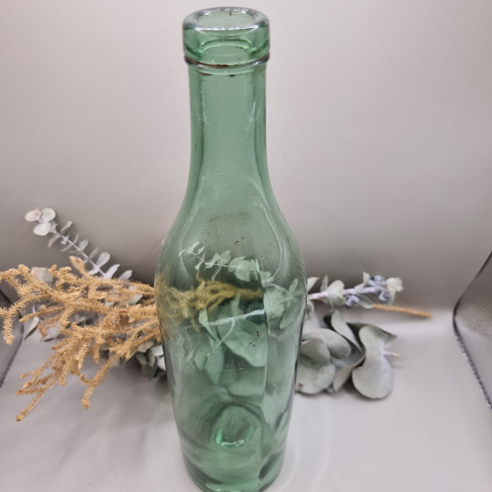 Vintage green glass bottle with soft green tint and rustic character