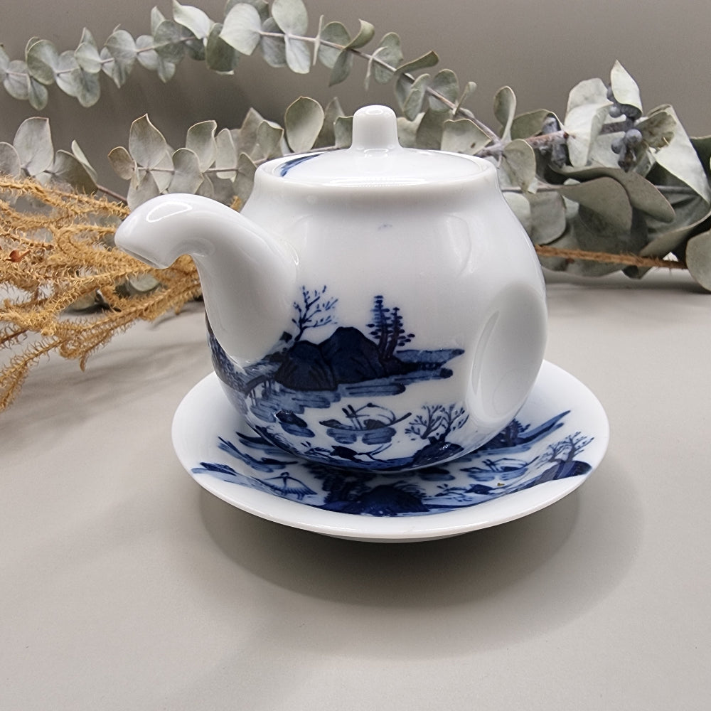Japanese blue and white sake pot with lid and matching saucer featuring Hill & Water landscape design