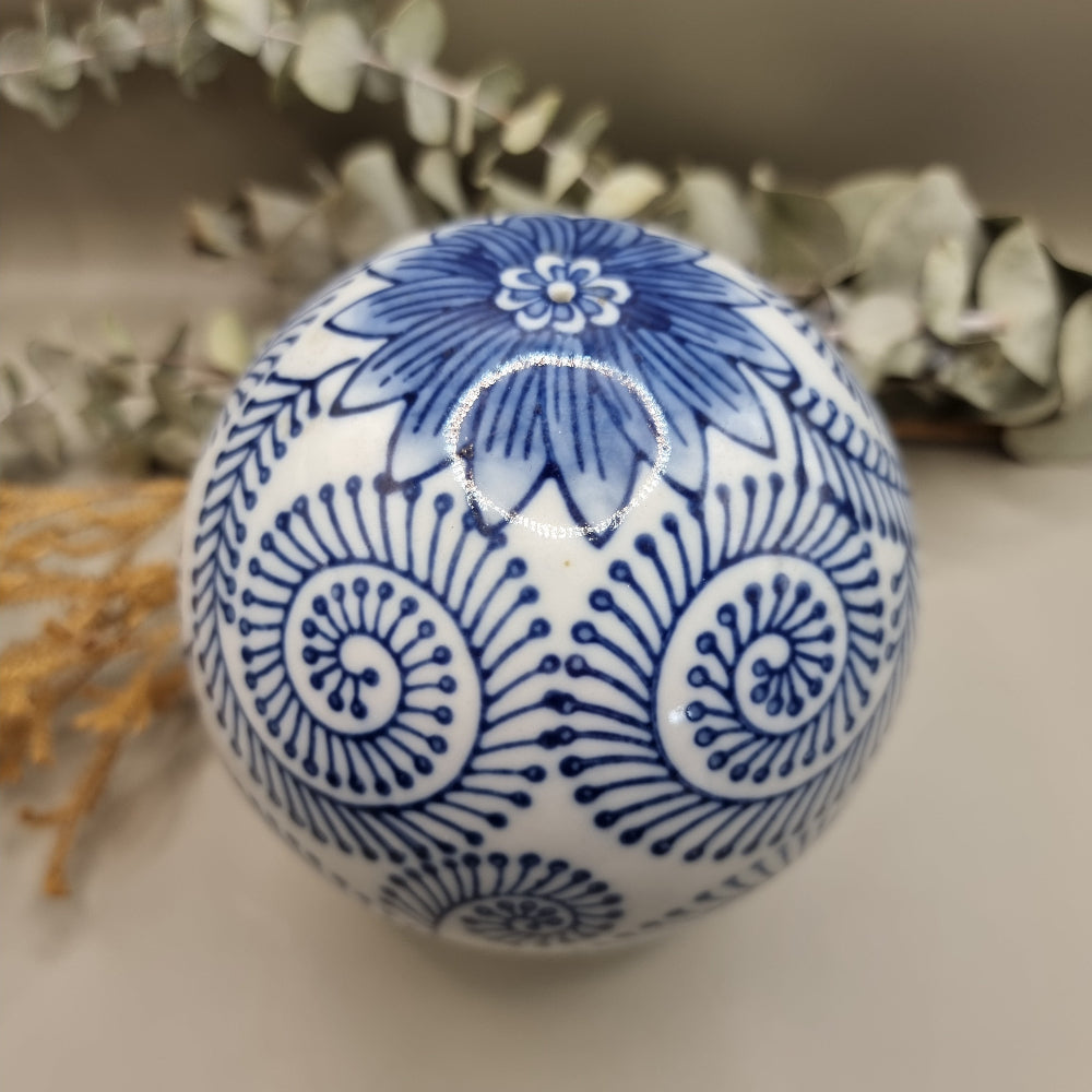 Blue and white ceramic sphere with spiral and floral patterns, decorative orb.