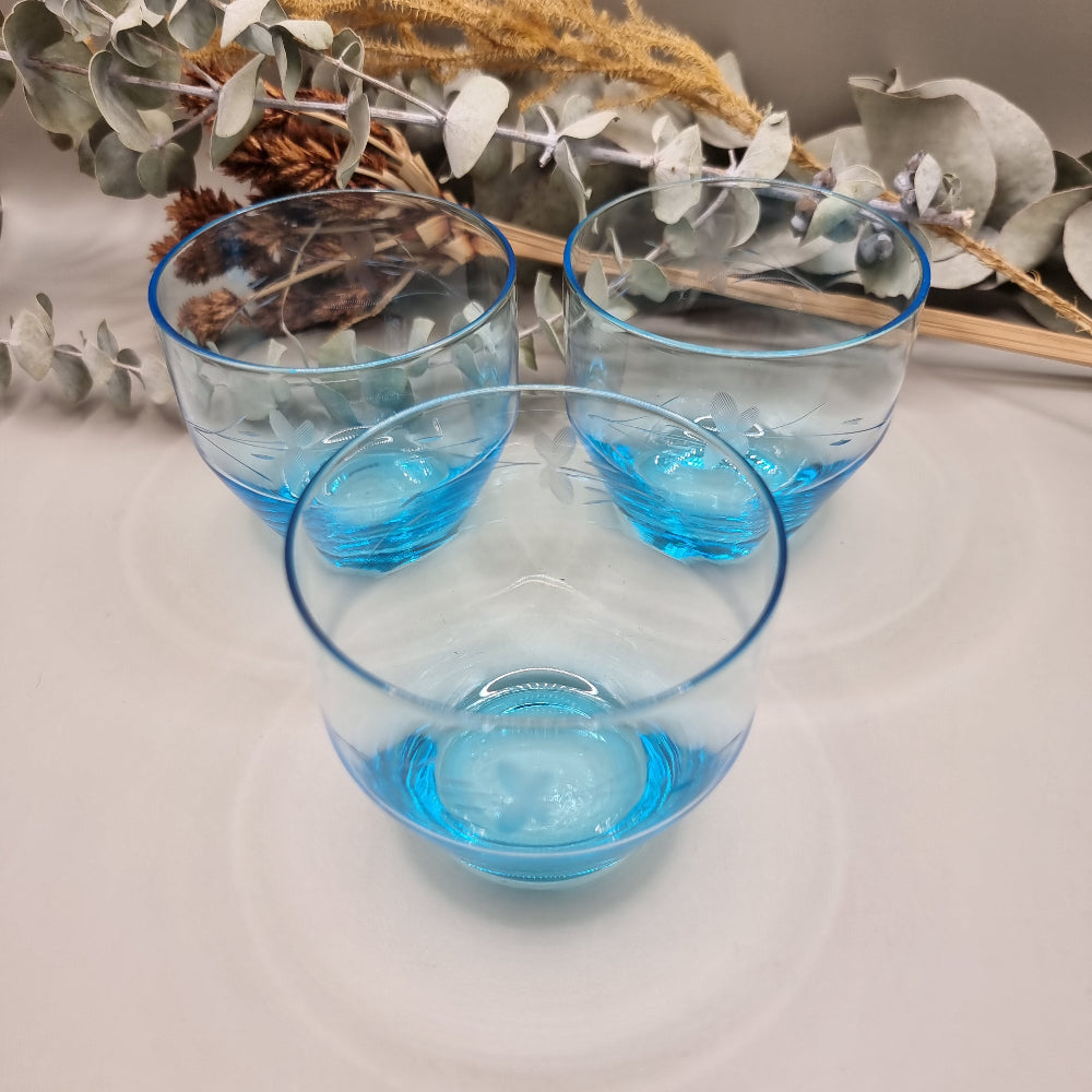 Set of 3 aqua blue glass tumblers with etched floral design.
