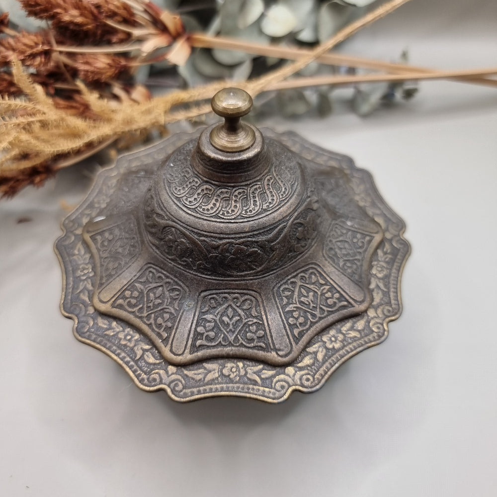 Ornate silver and gold-toned lidded metal trinket dish with embossed patterns.