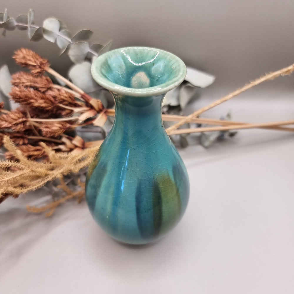Small turquoise and green glazed studio pottery vase with rounded base and slender neck.