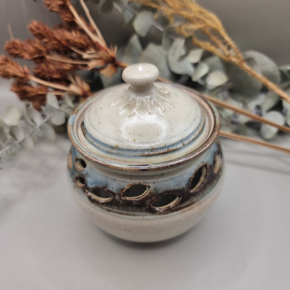 Handmade pottery jar with lid, blue-grey glaze and cutouts, signed FS on base