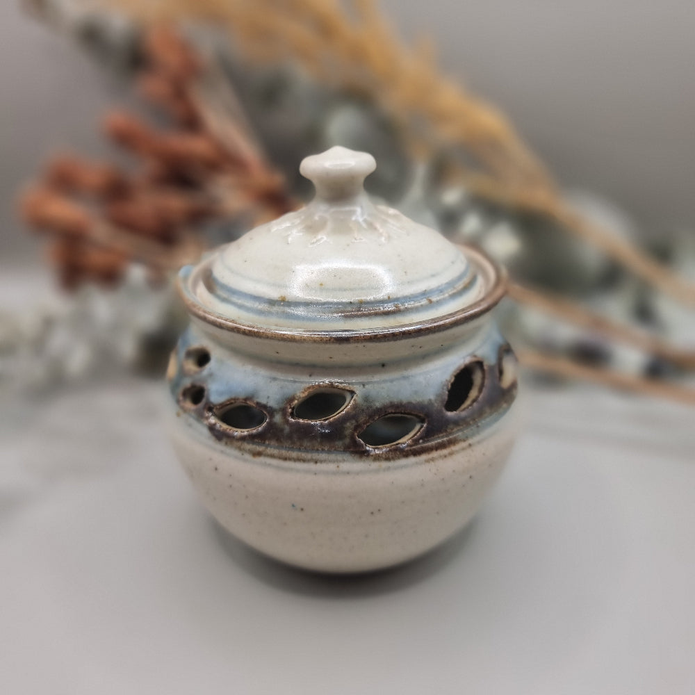 Handmade pottery jar with lid, blue-grey glaze and cutouts, signed FS on base