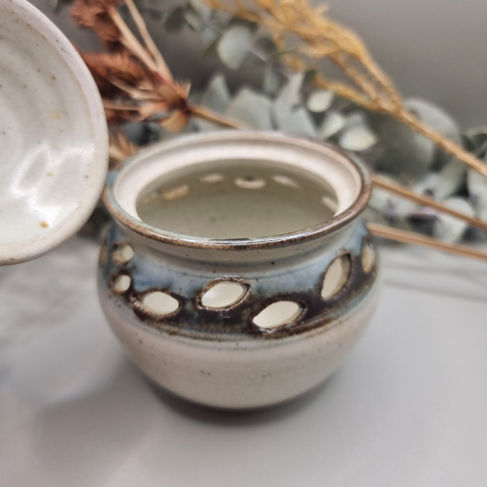 Handmade pottery jar with lid, blue-grey glaze and cutouts, signed FS on base
