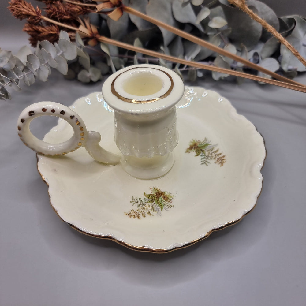 Cream ceramic candle holder with fern design, gold trim, and dotted handle