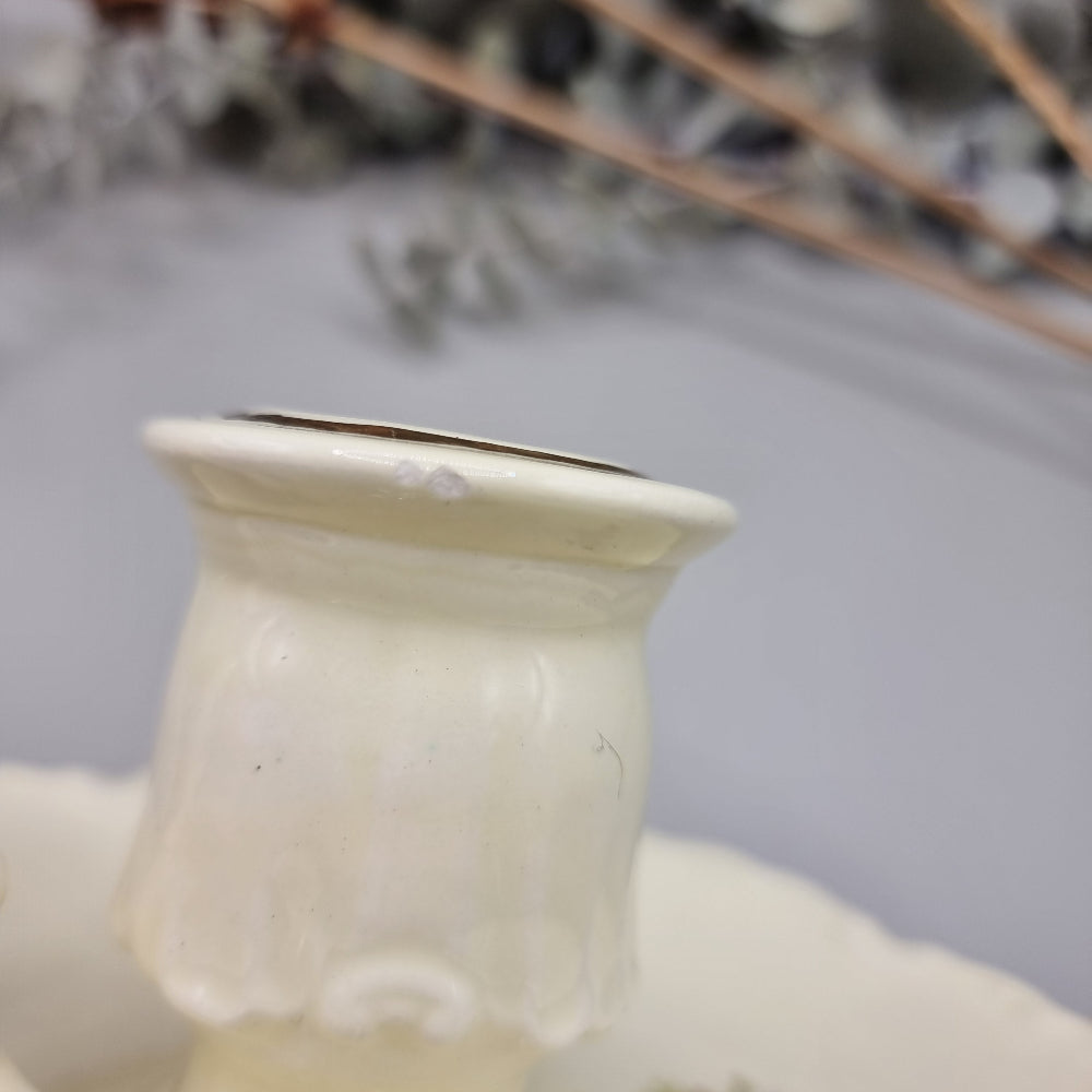 Cream ceramic candle holder with fern design, gold trim, and dotted handle