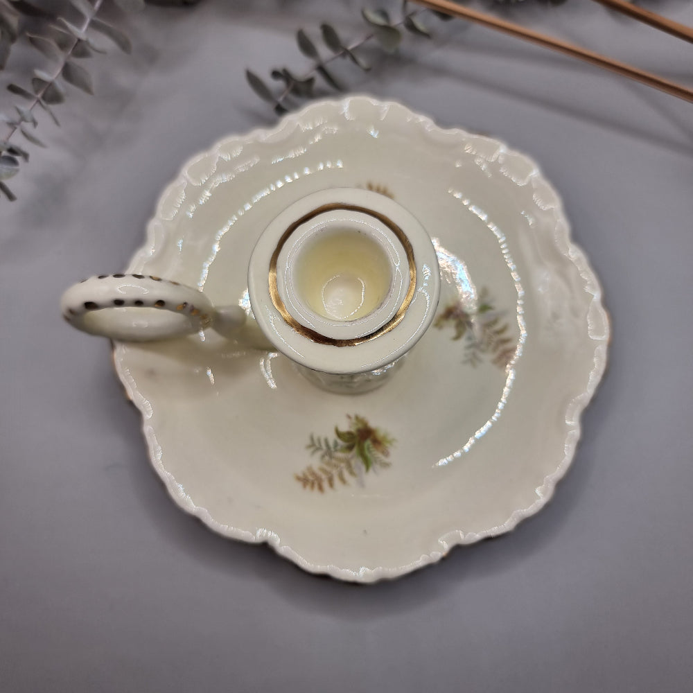 Cream ceramic candle holder with fern design, gold trim, and dotted handle