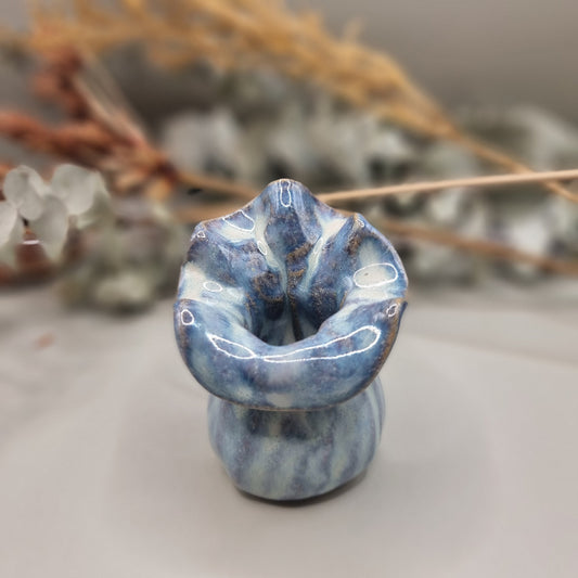 Small blue handmade pottery vase with ruffled rim and marbled glaze pattern.