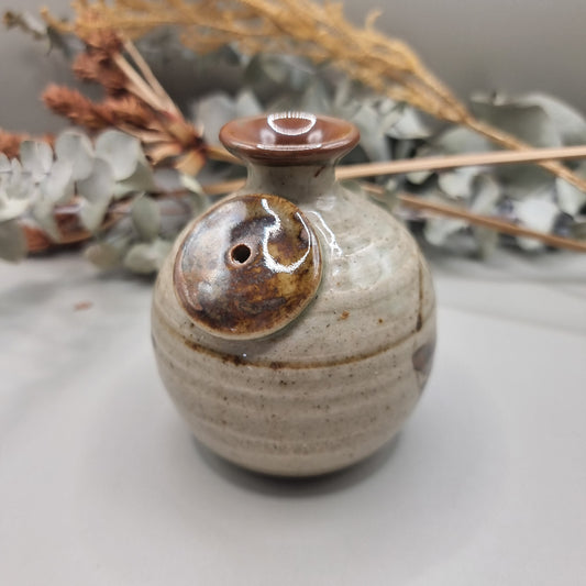 Vintage Norfolk Island pottery vase with speckled glaze and brushstroke detail.