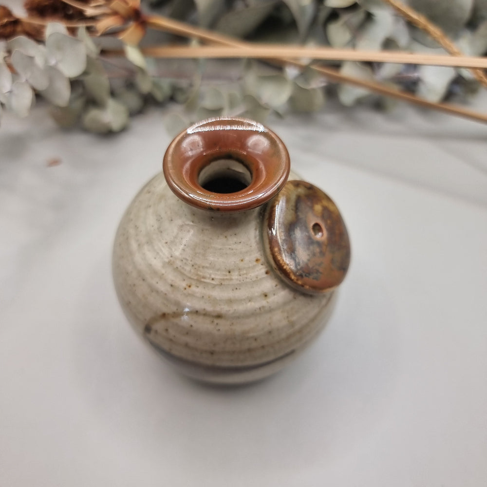Vintage Norfolk Island pottery vase with speckled glaze and brushstroke detail.