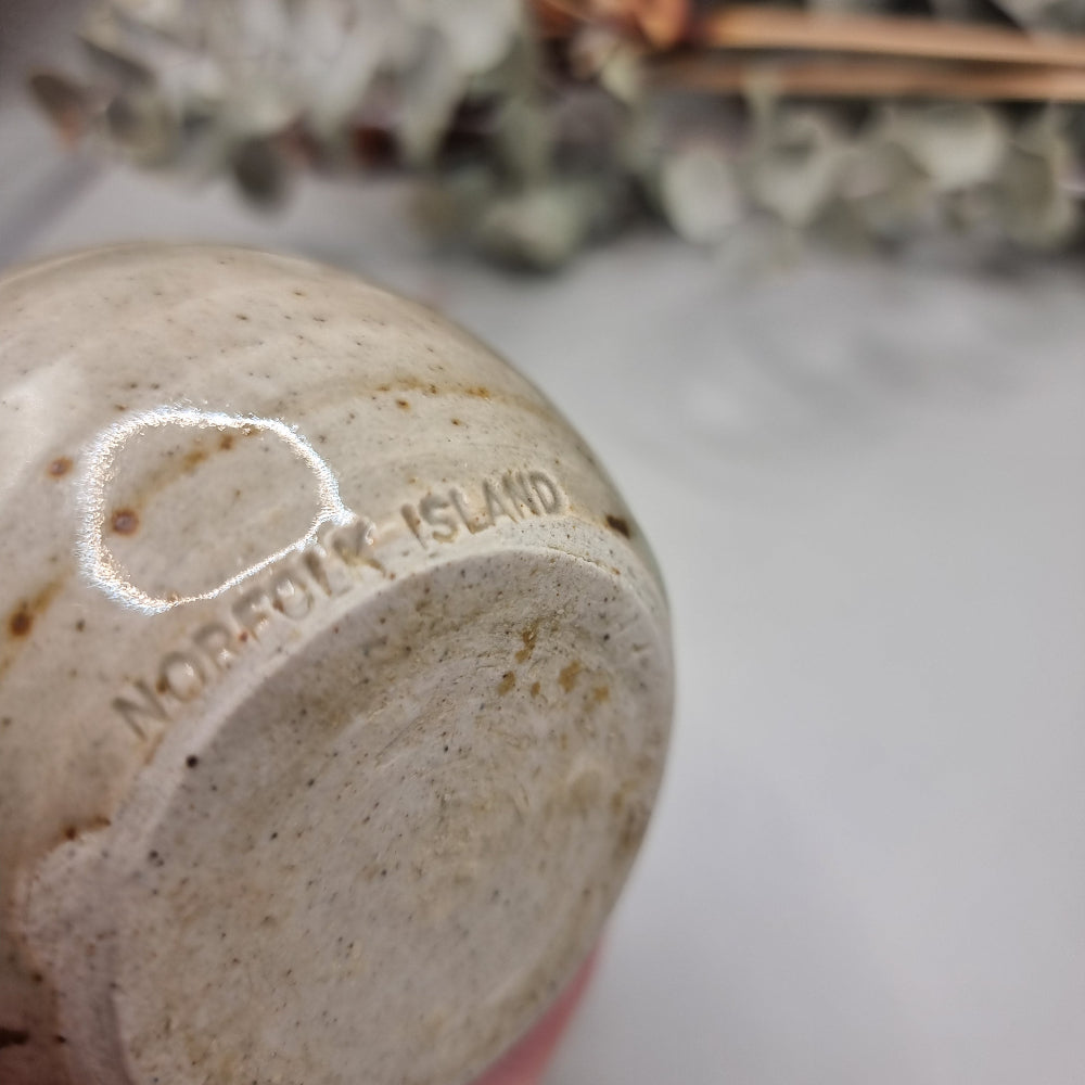 Vintage Norfolk Island pottery vase with speckled glaze and brushstroke detail.
