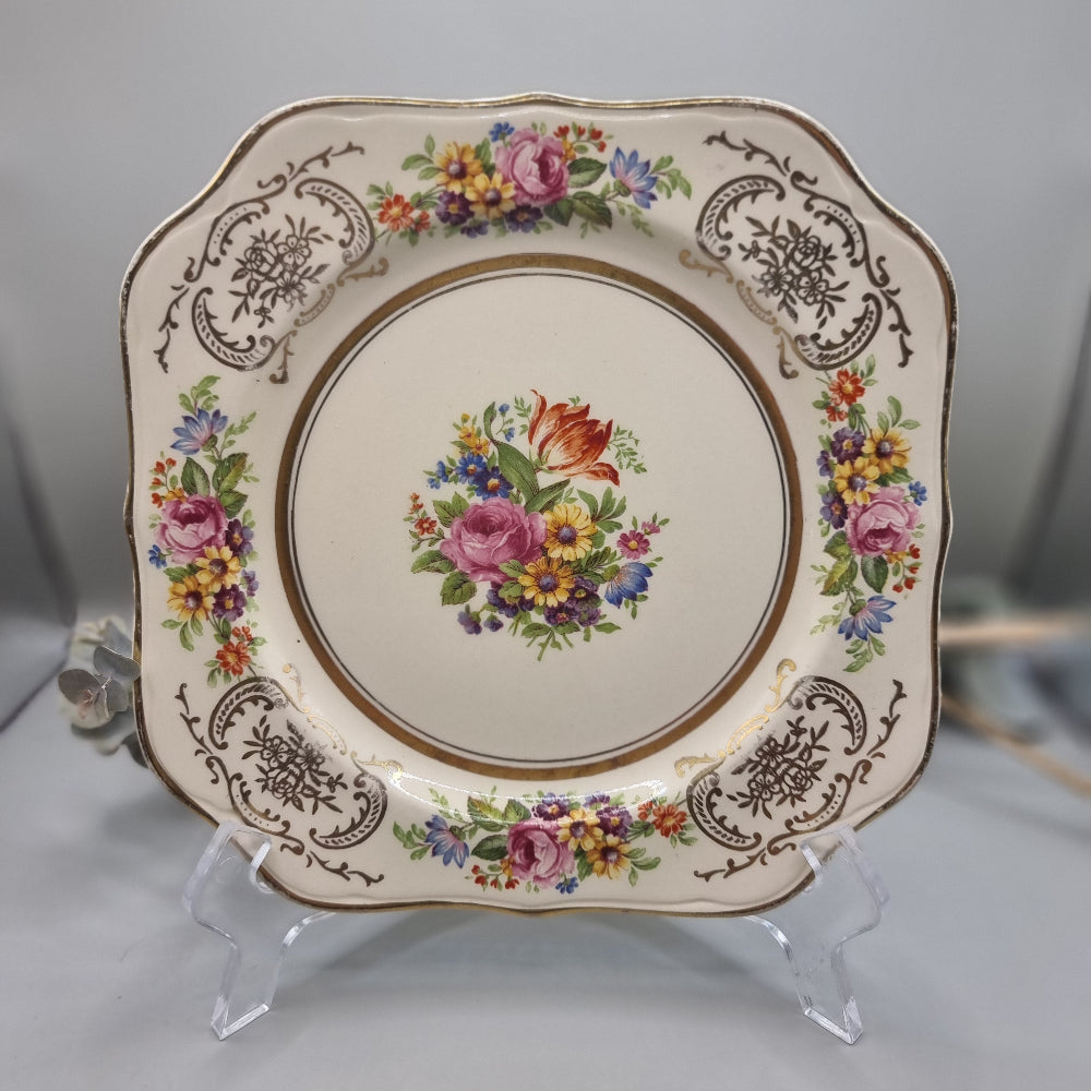 Johnson Bros Victorian square plate with floral centre and corner bouquets, gold edge and brown scroll detail.