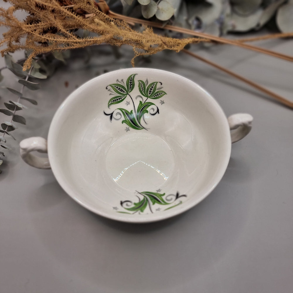 Set of two white ceramic soup bowls with green floral leaf design and twin handles