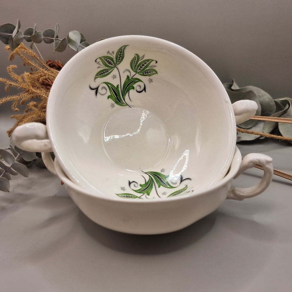 Set of two white ceramic soup bowls with green floral leaf design and twin handles