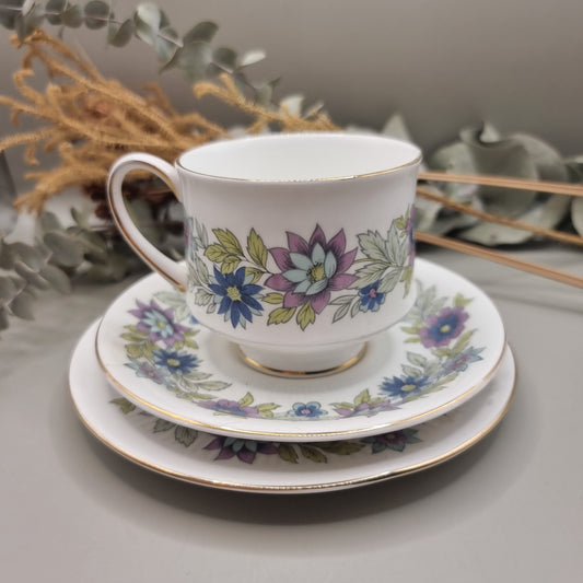 Two Paragon Cherwell bone china trios with soft floral design and gold rim.