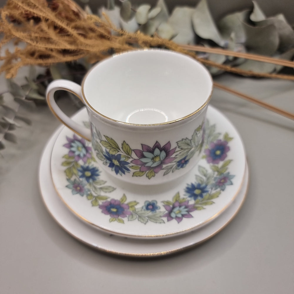 Two Paragon Cherwell bone china trios with soft floral design and gold rim.