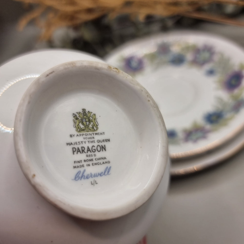 Two Paragon Cherwell bone china trios with soft floral design and gold rim.