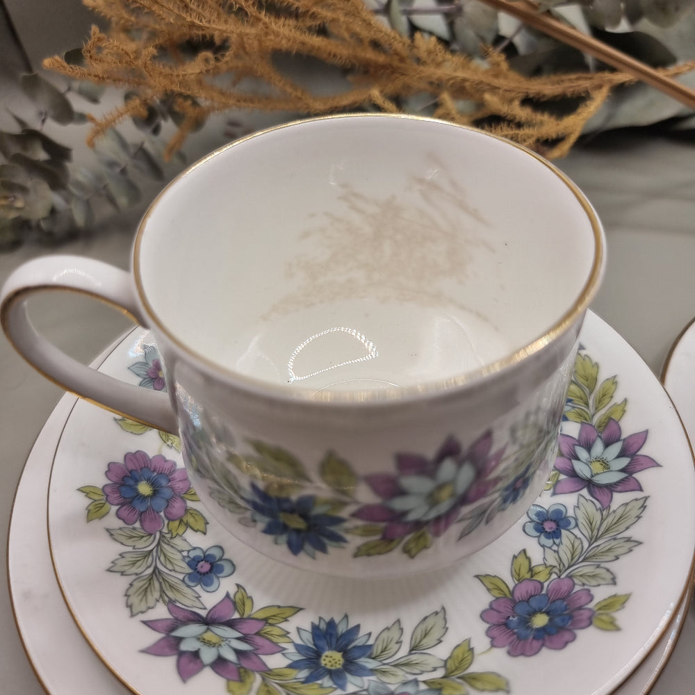 Two Paragon Cherwell bone china trios with soft floral design and gold rim.