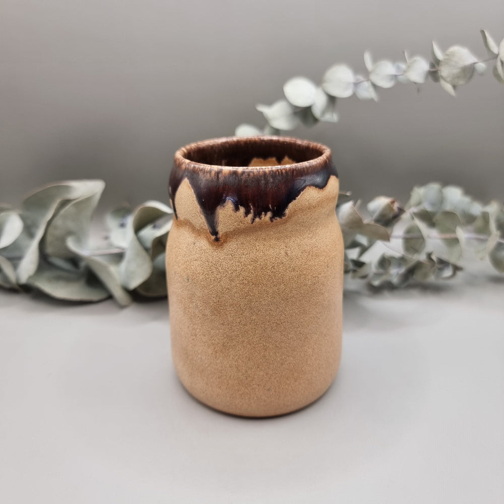 Studio pottery jar with sandy matte base and brown drip glaze rim