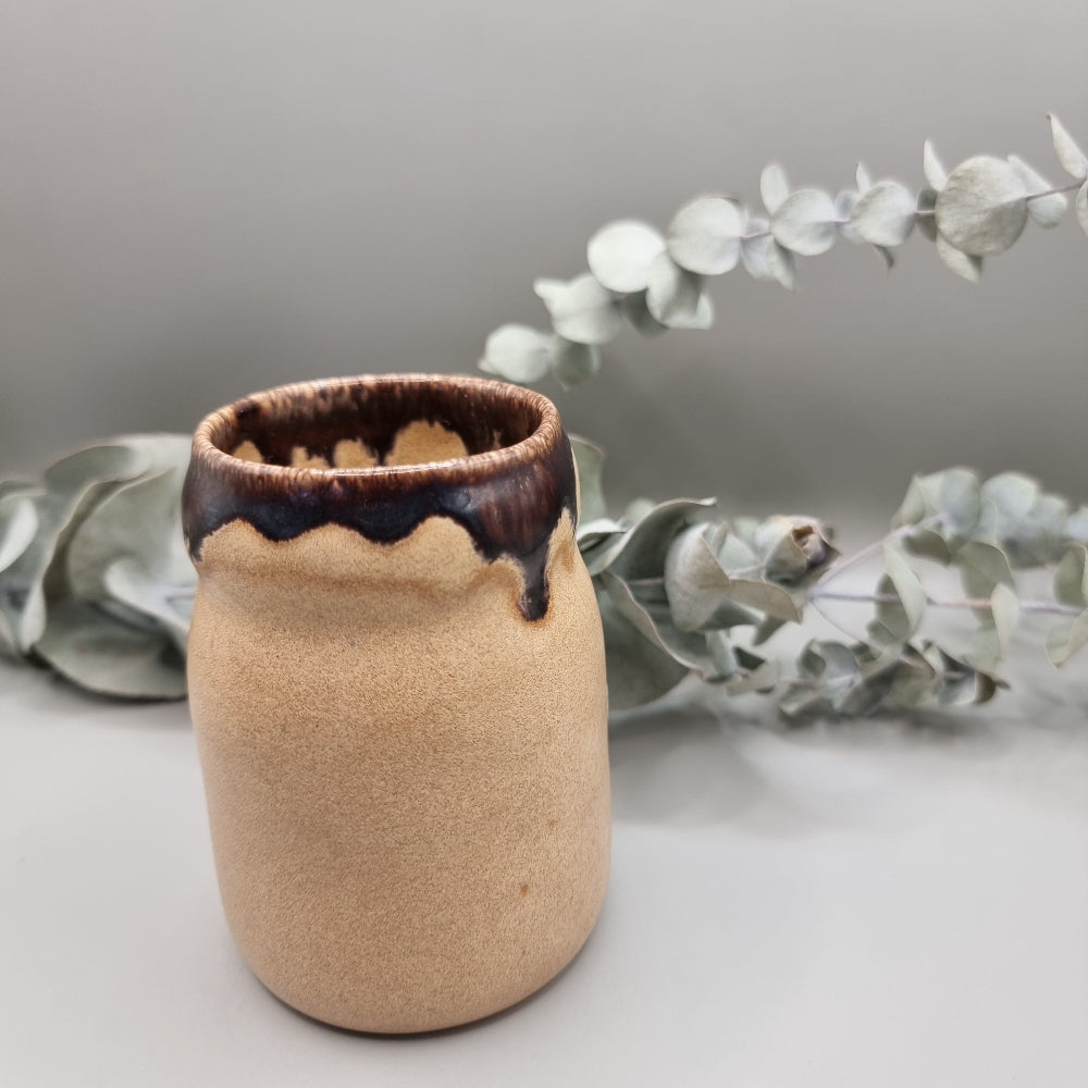 Studio pottery jar with sandy matte base and brown drip glaze rim