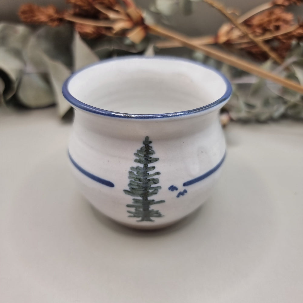 Norfolk Island pottery cup with pine tree design and blue rim