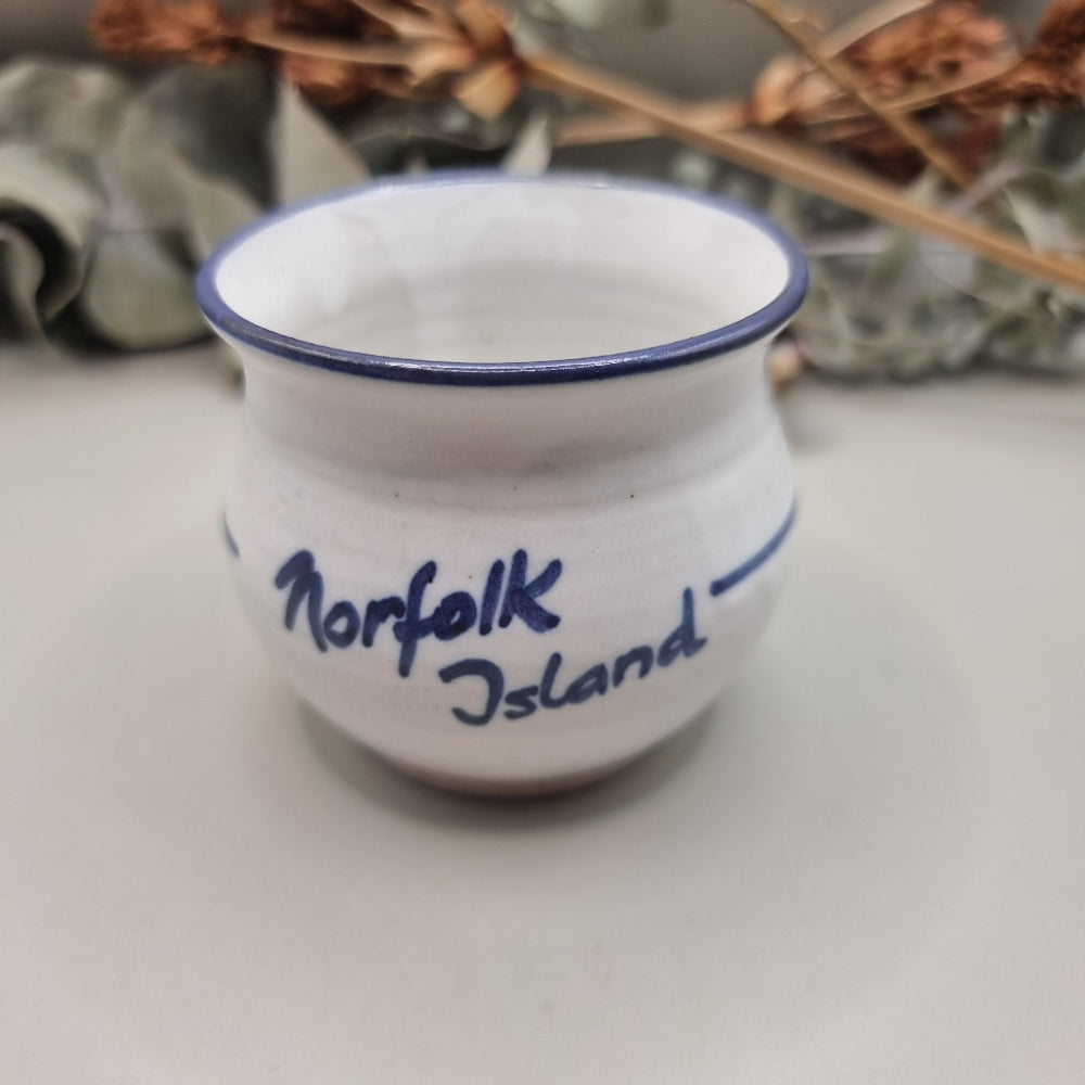 Norfolk Island pottery cup with pine tree design and blue rim