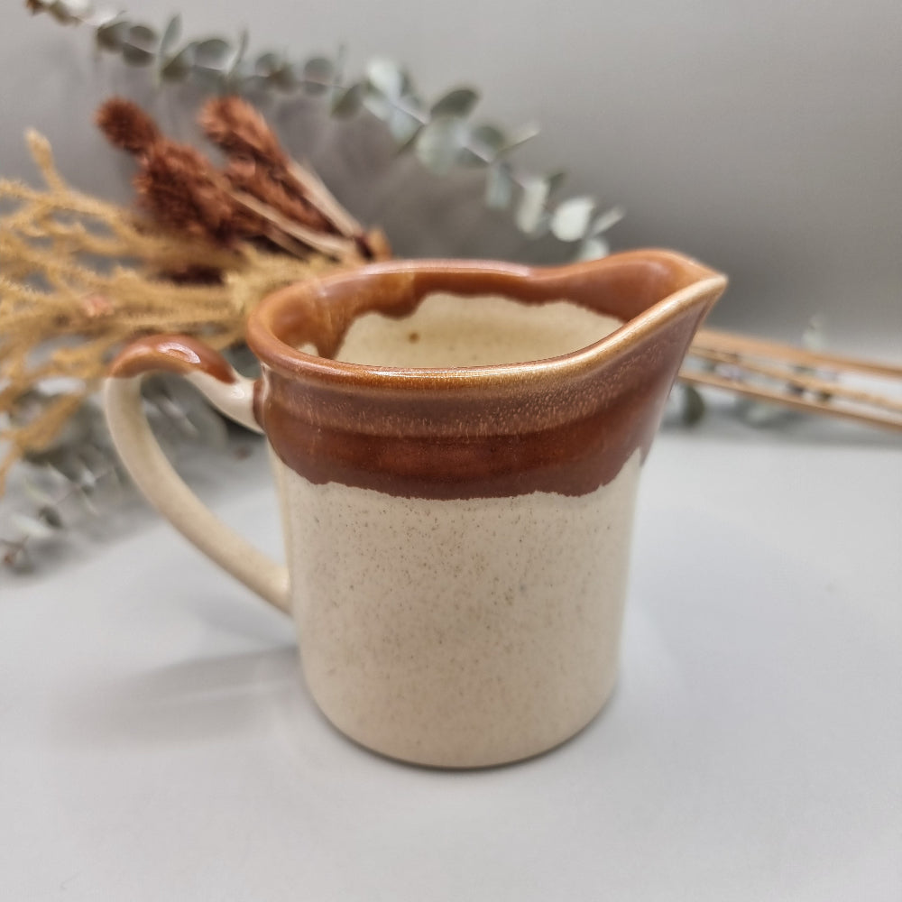 Titian Pottery NZ milk jug with caramel brown drip glaze and speckled finish.