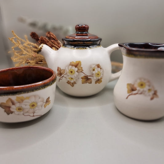 Stoneware teapot set with white floral design, includes teapot, creamer and sugar bowl.