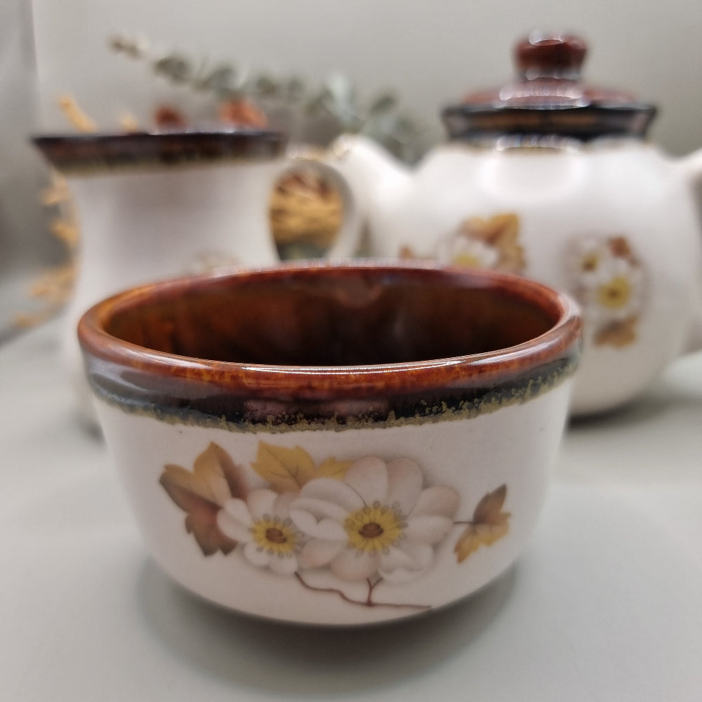 Stoneware teapot set with white floral design, includes teapot, creamer and sugar bowl.
