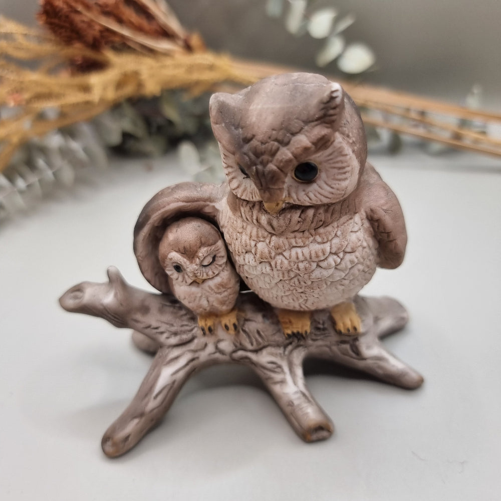 Ceramic ornament of a parent owl and baby owl perched on a branch.