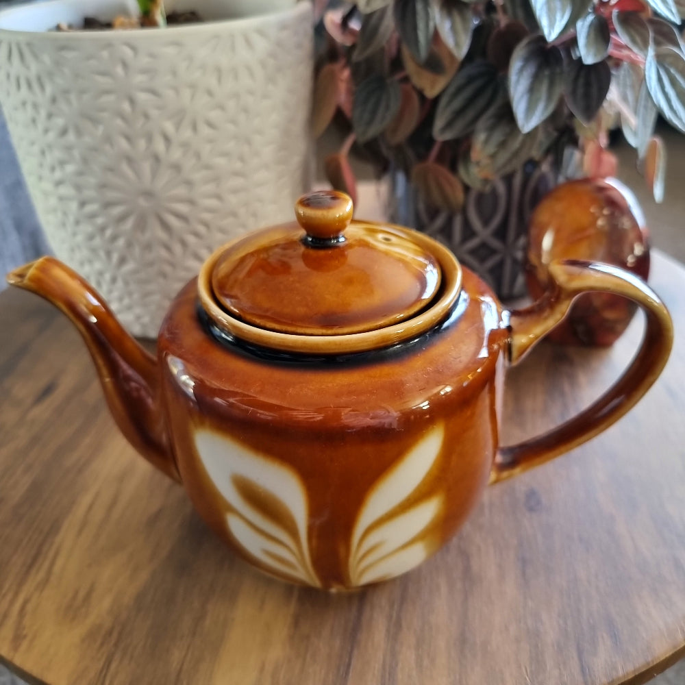 Vintage caramel and cream ceramic teapot with retro leaf design and matching lid