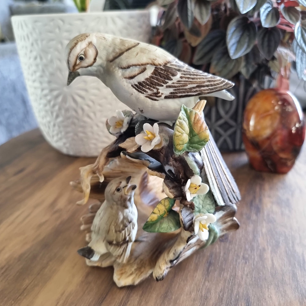 Vintage porcelain bird figurine with two birds, flowers, and leaves on a naturalistic base
